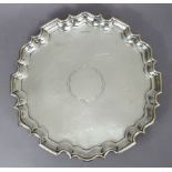 A George V silver salver with raised pie-crust border & planished surface, a plain reserve to