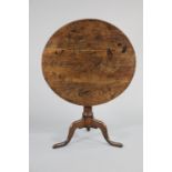 An oak tripod table with a circular tilt-top & “birdcage” support on a tapered gun-barrel column &