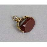 A three-sided carnelian swivel fob seal with 9ct gold mounts.