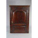 A Georgian mahogany large hanging corner cupboard with a moulded cornice above four shaped shelves