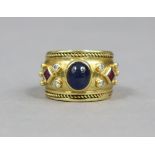 A heavy yellow metal ring set oval cabochon sapphire flanked by pairs of small diamonds & a square-