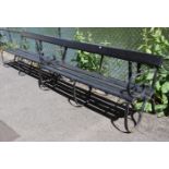 A pair of early/mid-20th century painted wooden benches on wrought-iron frames, each bearing