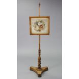 A burr walnut pole screen inset floral needlework panel, on a turned support with tri-form base,
