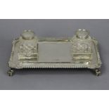 A late Victorian silver inkstand of rectangular shape, with gadrooned rim & shell corners, fitted