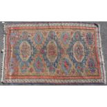 A Soumak rug of ochre ground featuring repeating geometric & floral designs within two narrow