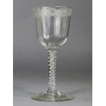 An 18th century drinking glass with engraved floral decoration to the rim, on air-twist stem &