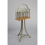 An early 20th century oak & brass revolving magazine rack on triform supports, stamped “HALL, B.
