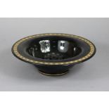 A black glass circular flower bowl with gilt geometric decoration to the wide rim, & on short