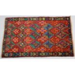 A new Baluchi rug of madder ground with repeating geometric designs & narrow floral border, 33” wide