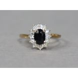 A 9ct gold ring set oval sapphire within a border of tiny diamonds, size O, 2g.