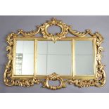 A giltwood triple-panel rectangular over-mantel mirror in a carved & pierced foliate-scroll frame,