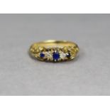 An 18ct gold ring set three small oval sapphires with two small diamonds in between, size K,