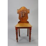 A mahogany hall chair with carved shield-shaped back, hard seat with canted corners, on turned &