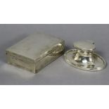 A George V silver inkstand of oval capstan form with slightly domed hinged cover, 4¼” wide,