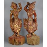 A pair of Balinese carved & painted standing figures decorated with applied sequins & coloured