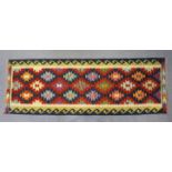 A Chobi kilim runner of deep blue ground with repeating multicoloured lozenge design in cream &