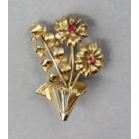 A yellow metal brooch in the form of two flowers, each set small ruby to centre, marked “750”, 1½”