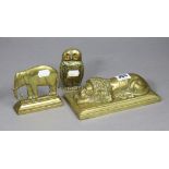 A 19th century cast brass model of a sleeping lion, on flat rectangular base, 7¼” wide; a ditto