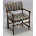 A 1920’s oak bobbin-frame elbow chair with a padded seat & back.