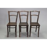 A set of four bentwood café chairs with hard seats, & on four round tapered legs.