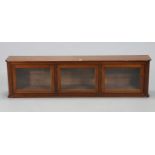 A mahogany wall cabinet with an adjustable shelf enclosed by three glazed doors, & with panelled