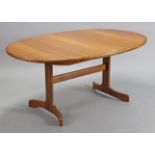 A G-Plan teak oval extending dining table with a centre leaf, & on square end supports joined by a