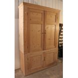 A 19th century pine tall cupboard (in two sections) fitted two shelves enclosed by two pairs of