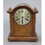 An Edwardian mantel clock with a silvered dial, striking movement, & in an inlaid-mahogany case,