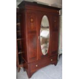 An Edwardian inlaid-mahogany wardrobe with a moulded cornice, enclosed by a bevelled oval mirror