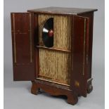 A mid-20th century mahogany record cabinet containing various vintage records enclosed by a pair