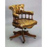 A mahogany & buttoned tan leather swivel desk chair on five splay legs with shepherd castors (w.a.