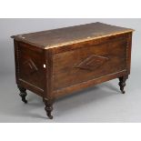 An oak coffer with a hinged lift-lid, having beaded panel front & sides, & on short turned legs with