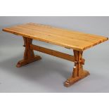 A pine refectory table on shaped end supports joined by a plain centre stretcher, 72” wide x 28¼”