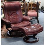 A stressless crimson leatherette swivel & reclining armchair; & a ditto rectangular footstool.
