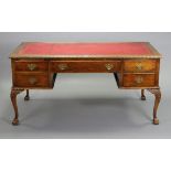 A 19th century-style walnut knee-hole desk inset gilt-tooled crimson leather to the rectangular top,