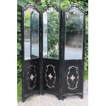 A continental-style ebonised & gold painted wooden frame three-fold draught screen inset bevelled
