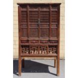 A CHINESE ELM TALL CABINET enclosed by two pairs of carved & pierced panel doors above four small