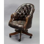 A buttoned dark green leather swivel desk chair on five splay legs with castors.