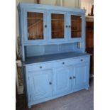 A pale blue painted pine tall cabinet the upper part fitted shelf enclosed by three glazed doors,