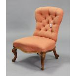 A Victorian buttoned-back nursing chair upholstered pink material, & on short carved cabriole legs.