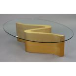 A contemporary blonde wood coffee table with a plate-glass oval top, 48¾” wide x 14¼” high; & a