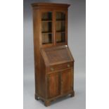 A 1930’s oak bureau-bookcase fitted two shelves enclosed by a pair of glazed doors with a fitted