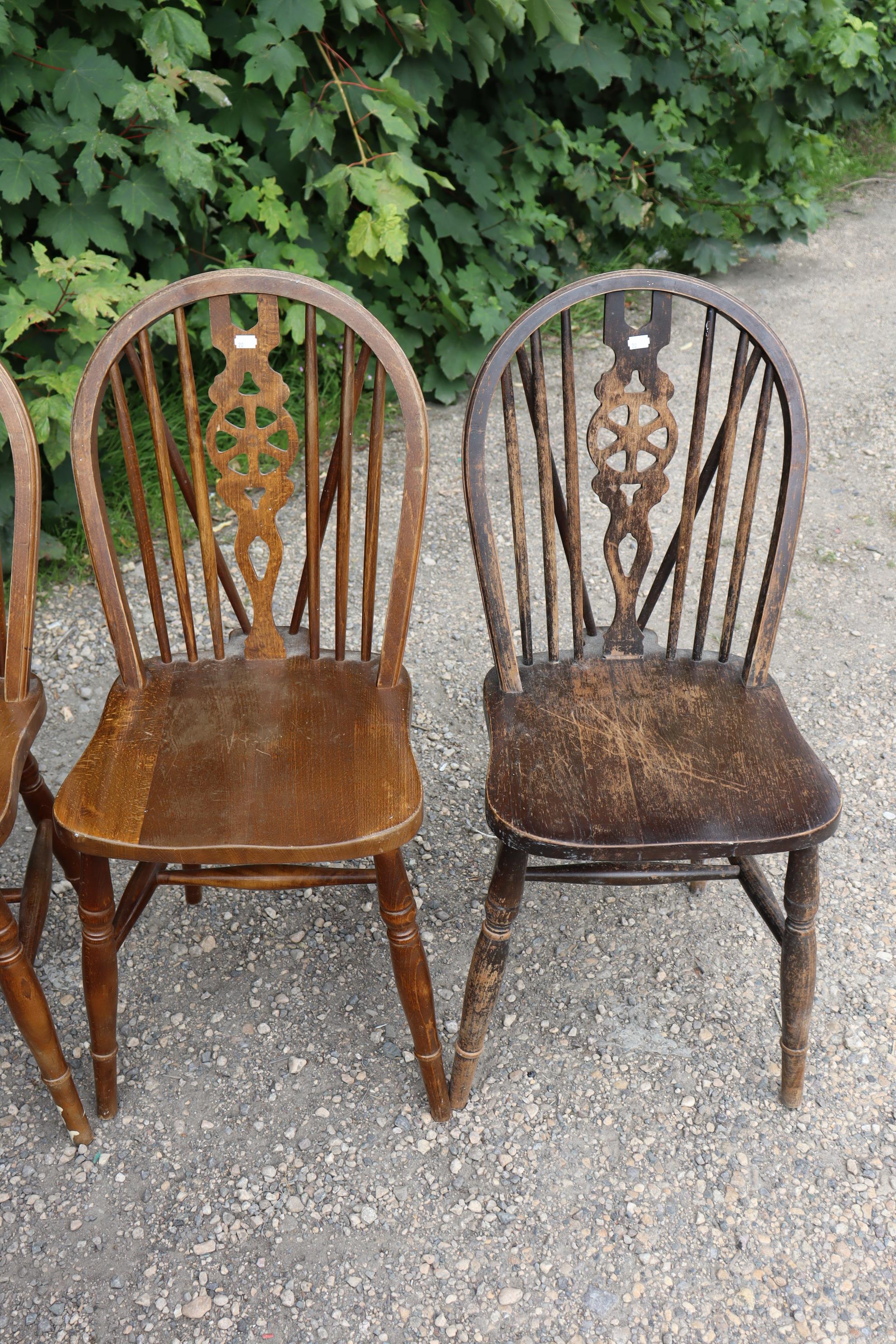 A set of six wheel-back dining chairs with hard seats, & on turned legs with spindle stretchers. - Image 4 of 6