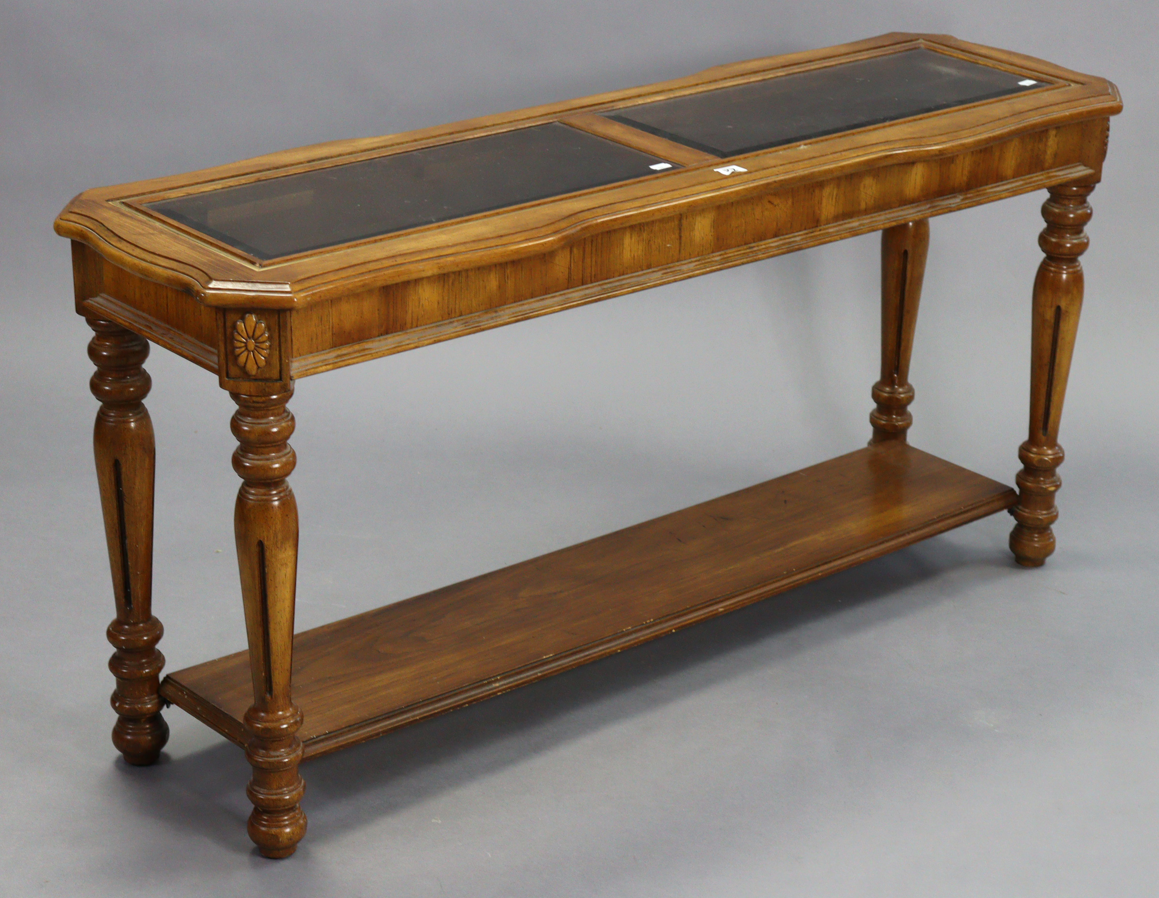 A walnut-finish rectangular two-tier side table inset two glass plates to the upper tier, & on