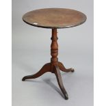 A 19th century oak tripod table with a circular tilt-top, & on vase-turned centre column & three