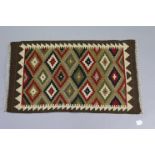A Kelim small rug of green ground with repeating geometric design.