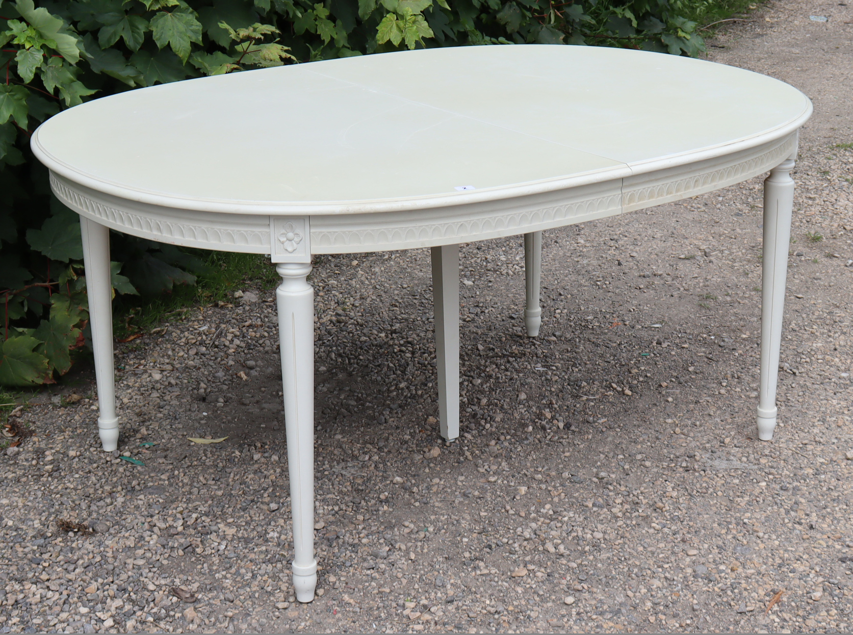 A GOOD QUALITY WHITE-FINISH EXTENDING DINING TABLE IN THE CONTINENTAL-STYLE with moulded edge to the
