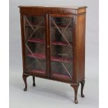 A small mahogany hanging corner cabinet fitted two plate-glass shelves enclosed by a glazed door,