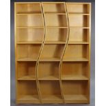 Three contemporary inter-locking curvilinear tall standing open bookcases, 58” wide x 79” high x 9¾”