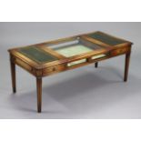 A reproduction mahogany display-top low coffee table enclosed by a glazed lift-top to centre flanked